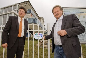 Der Präsident des Deutschen Tourismus Verbandes Reinhard Meyer und der Geschäftsführer der Touristik-Service-Kühlungsborn GmbH, Peter Brauer, bringen das 5-Sterne-Schild an der Strandresidenz-Kühlungsborn an.